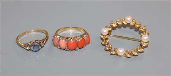 A diamond, coral and yellow metal half-hoop ring, a sapphire and diamond ring and a pearl and diamond-set laurel wreath brooch (3)